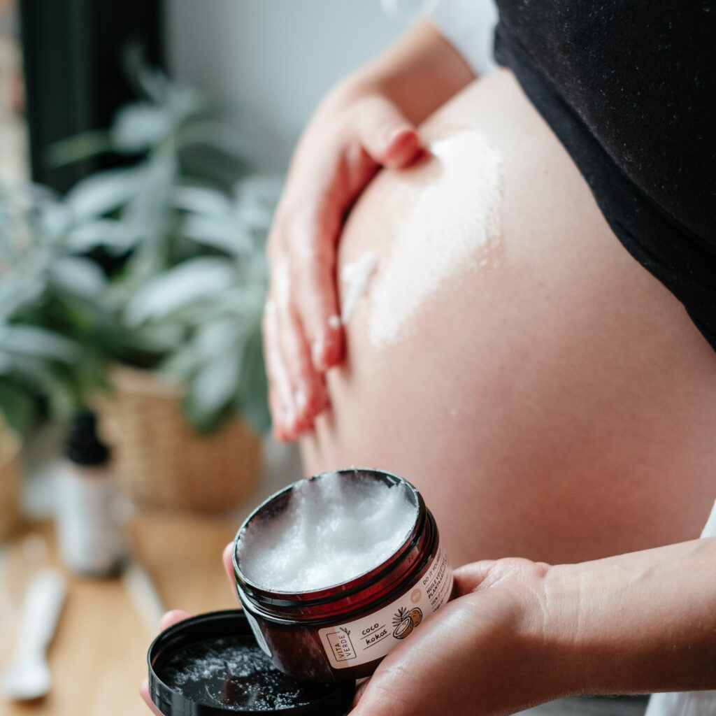 Ventre de femme enceinte avec huile de coco pour vergetures
